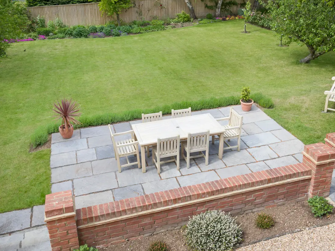 Sandstone patio with brick retaining wall